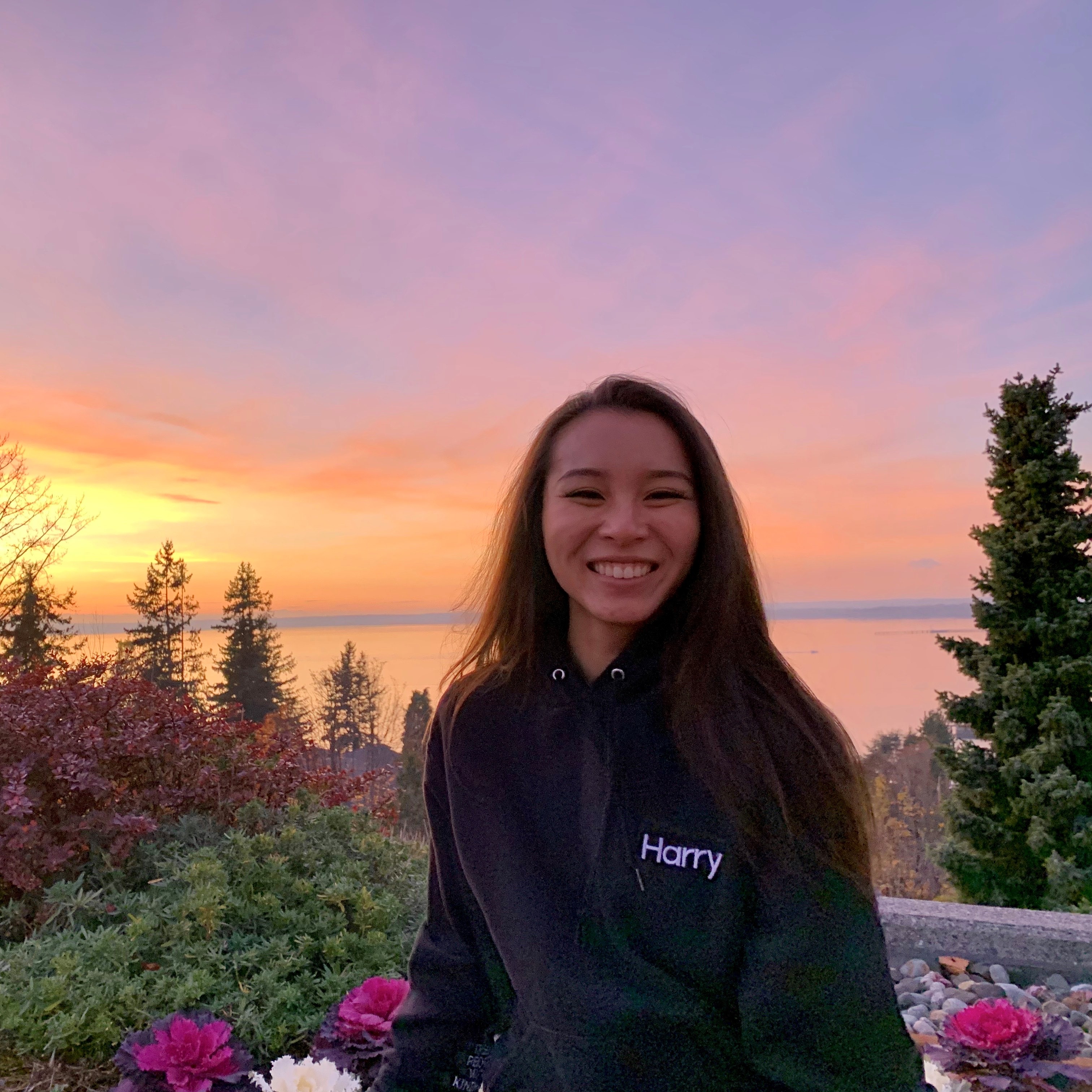 Victoria smiling at the camera during a sunset overlooking the Bellingham Bay