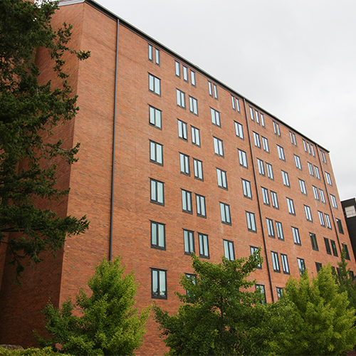 An exterior photo of the 8 floors of Buchanan Towers taken from Bill McDonald Parkway