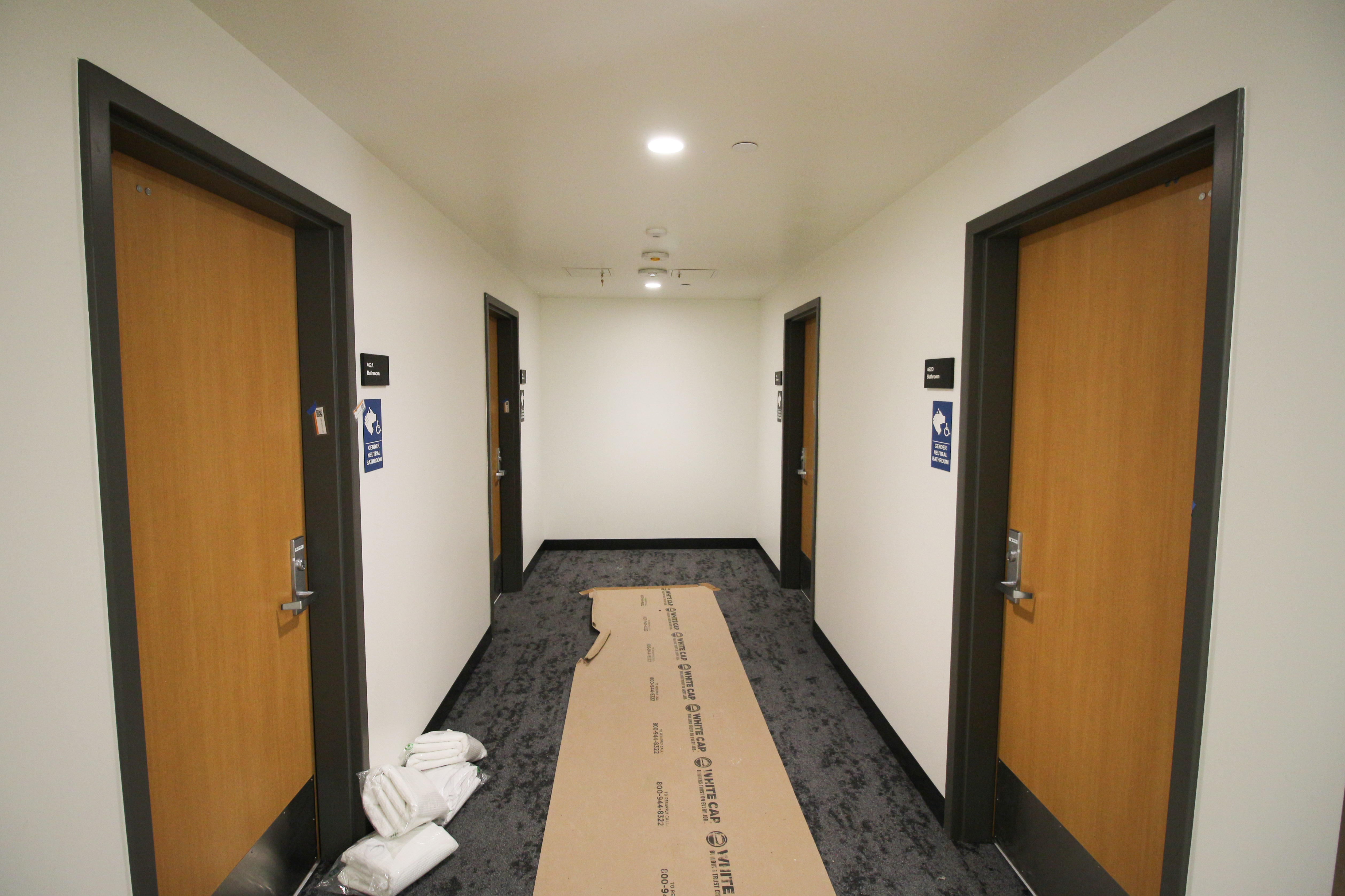 Short hallway with doors to gender-neutral bathrooms on either side