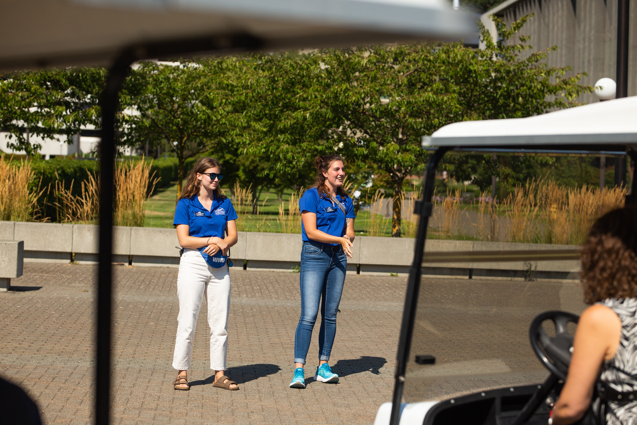 Two students in blue shirts guide a tour of campus