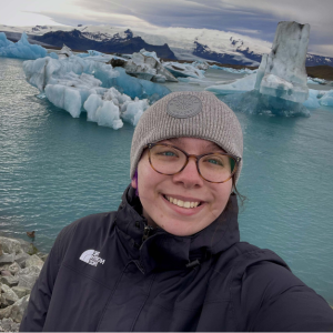 Hannah smiles at camera with glaciers in the background