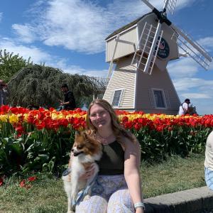 Brianna holding a dog in front of tulips